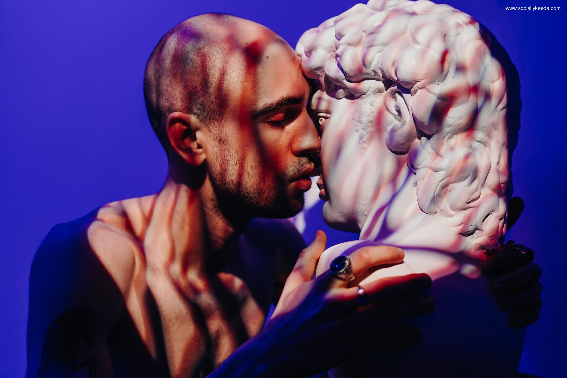 man kissing a gypsum head